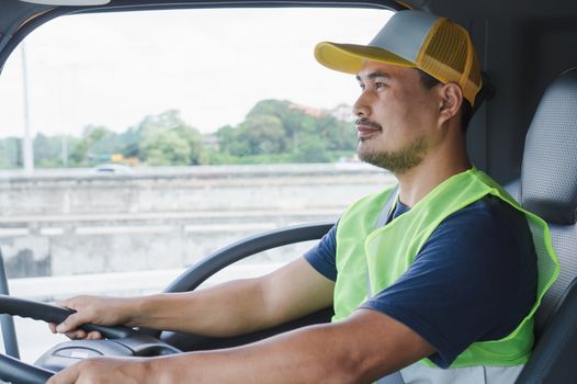 Professional worker truck driver, confident middle-aged Asian man wearing safety clothing Smile proudly In moving forward For a long transportation business