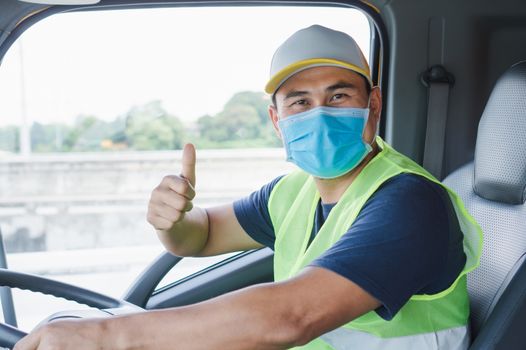 Professional worker, truck driver, middle-aged Asian man wearing protective mask And safety vests For a long transportation business