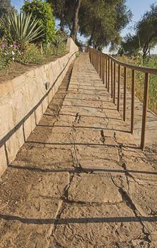 Sloping paved stone footpath in rural countryside landscape garden grounds scene