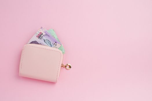 Wallet with Thai currency banknote on pink background for business, finance, investment and saving money concept