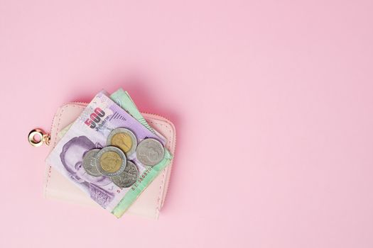 Thai currency banknote and money coins with wallet on pink background for business, finance, investment and saving money concept