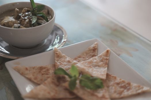 fried roti & green curry chicken coconut milk soup. traditional indian muslim food