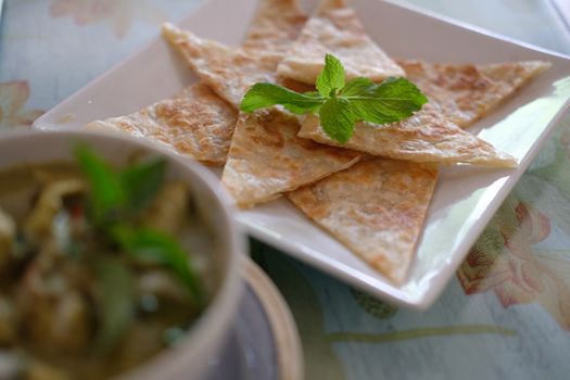 fried roti & green curry chicken coconut milk soup. traditional indian muslim food