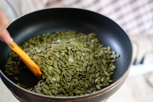 grilling toasting roasting pumpkin seed cereal on pot