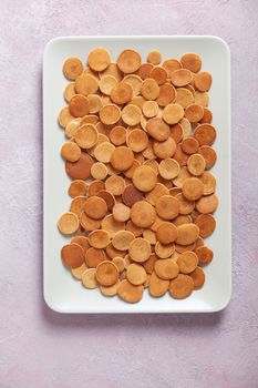 Trendy homemade breakfast, pancake cereal, mini pancakes on light plate on pink concrete background