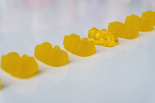 Row of multicolored jelly bears candy on a white background.