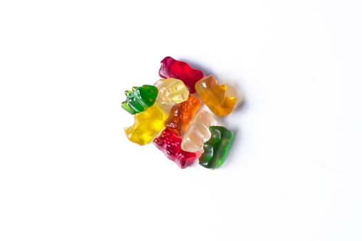 Pile of multicolored jelly bears candy on a white background.