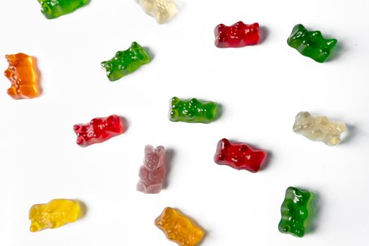 Pile of multicolored jelly bears candy on a white background.