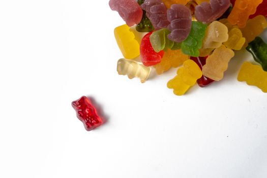 Pile of multicolored jelly bears candy on a white background.