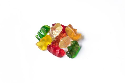 Pile of multicolored jelly bears candy on a white background.