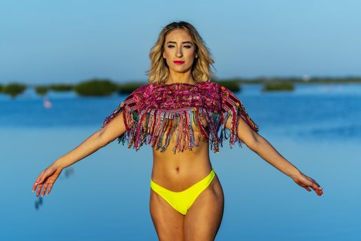 A beautiful model poses with the rising sun on an exotic Caribbean beach