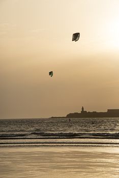 Essaouria, Morocco - September 2017: Early evening kite surfing as the sun starts to set over the ocean
