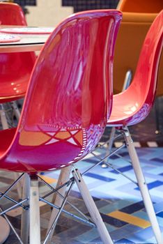 Essaouria, Morocco - September 2017: Red plastic chair ouside of cafe reflecting star deisgn in floor mosaic
