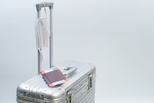 Luggage passport boarding pass and face mask, new normal travel concept.(Fake barcode)