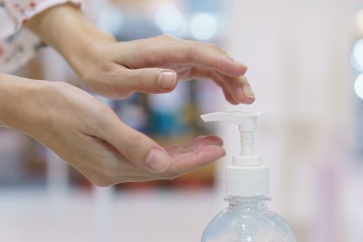 Woman hand press sanitizer bottle to clean her hand. hygiene prevention of coronavirus (Covid-19) virus outbreak.
