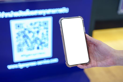 Mockup, hands holding blank white screen mobile phone in blurred QR code , digital payment concept