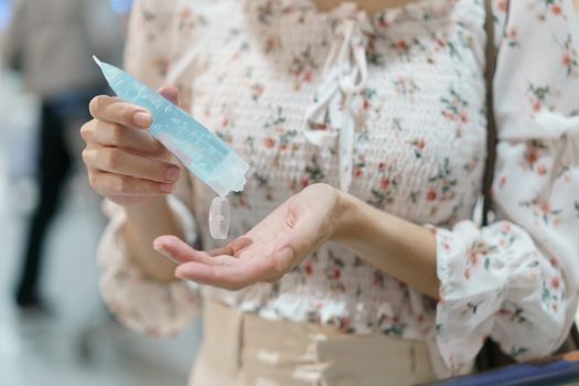 Woman using hand sanitizer spray from her hand bag, prevention of coronavirus.