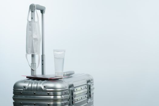 Luggage passport boarding pass sanitizer bottle and face mask, new normal travel concept.