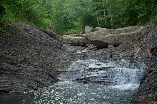 Mountain river in the stone bed at summer