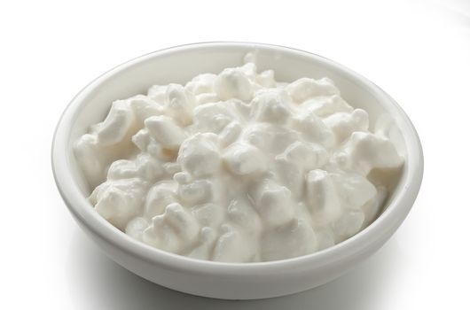 Grained cottage cheese in the white bowl