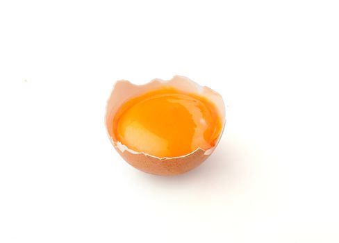 Yolk in the broken eggshell on the white background