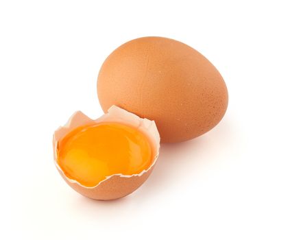 Yolk of egg in broken eggshell and whole egg