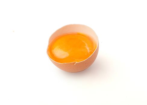 Yolk in the broken eggshell on the white background