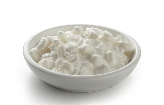 Grained cottage cheese in the white bowl