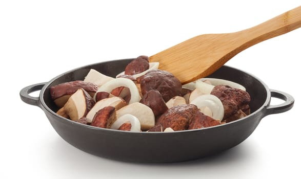 Sliced white mushrooms with onion rings in the black iron pan