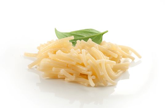 Isolated boiled vermicelli with fresh green basil on the white plate