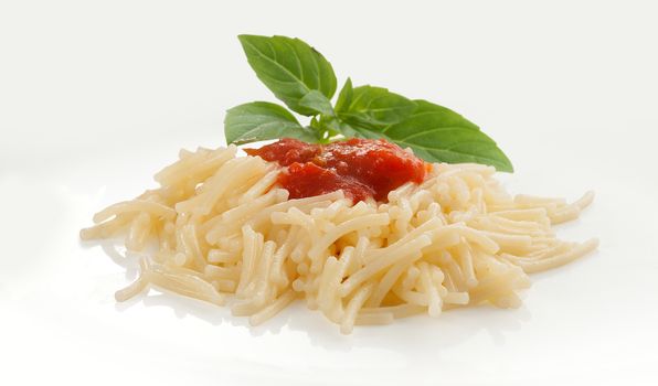 Isolated boiled vermicelli with fresh green basil on the white plate