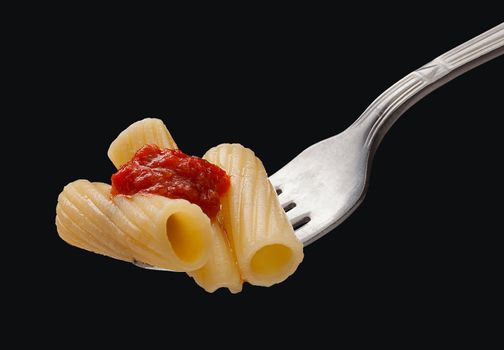 Pasta on the fork on the black background