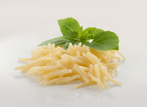 Isolated boiled vermicelli with fresh green basil on the white plate