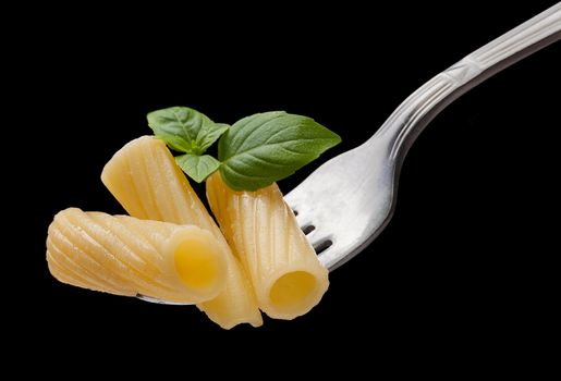 Pasta on the fork on the black background