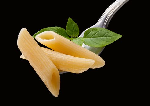 Pasta on the fork on the black background