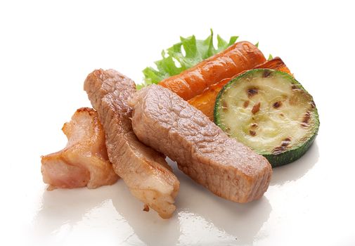 Pork roast with fried carrot, fried zucchini and fresh green lettuce
