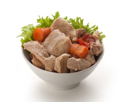 Pieces of roasted pork with fresh lettuce and fried vegetables in the bowl