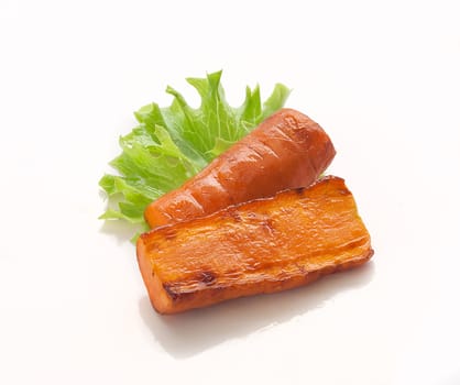 Two pieces of roasted carrot on the fresh green lettuce