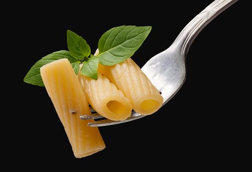 Pasta on the fork on the black background