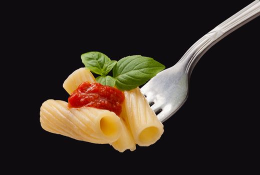 Pasta on the fork on the black background