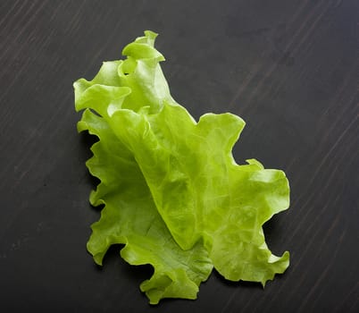 Top view of green fresh lettuce on the black wooden table