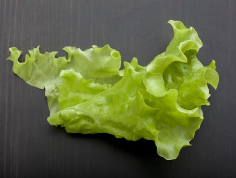 Top view of green fresh lettuce on the black wooden table