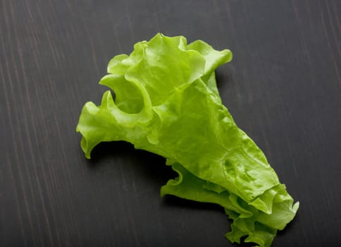 Top view of green fresh lettuce on the black wooden table