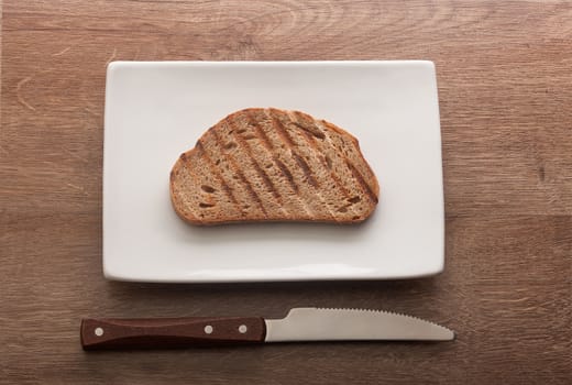 Top view of toasted rye bread on the white plate