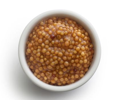 Top view of white plate with grainy mustard on the white background