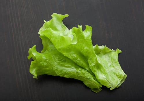 Top view of green fresh lettuce on the black wooden table