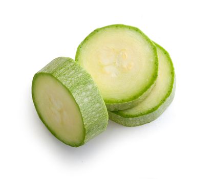 Three green pieces of vegetable marrow on the white background