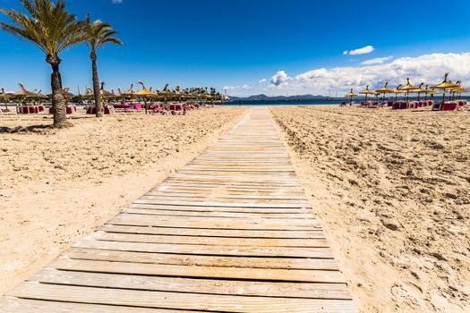 Wooden footpath on the sand beach on Mallorca island, beautiful seaside coast of Alcudia bay, Spain Balearic Islands