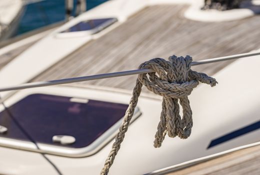Close-up of knotted nautical rope on railing of boat deck