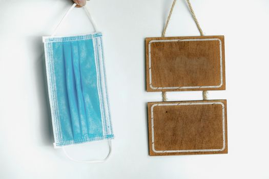 Sanitary mask and wooden sign on a white background